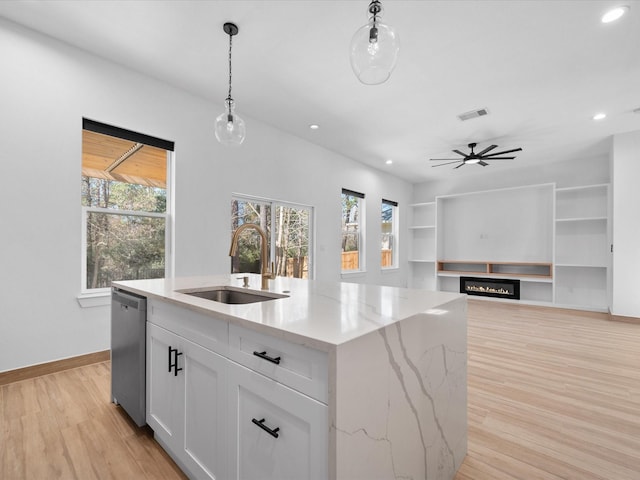 kitchen with pendant lighting, white cabinetry, sink, a kitchen island with sink, and stainless steel dishwasher