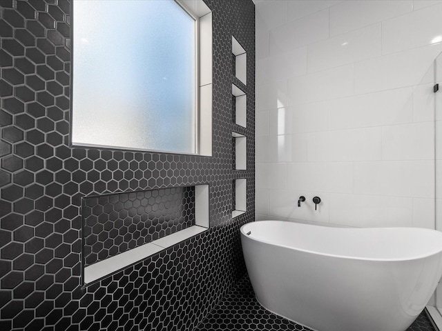 bathroom with a washtub and tile walls