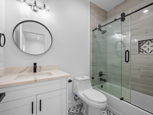 full bathroom featuring combined bath / shower with glass door, toilet, and vanity