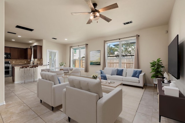 living room featuring sink, light tile patterned floors, and ceiling fan