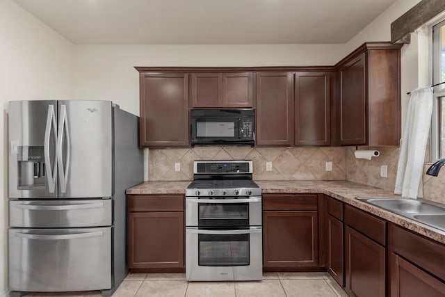 kitchen featuring decorative backsplash, sink, appliances with stainless steel finishes, and light tile patterned floors