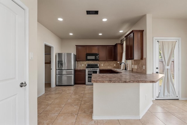 kitchen featuring sink, light tile patterned flooring, backsplash, and appliances with stainless steel finishes