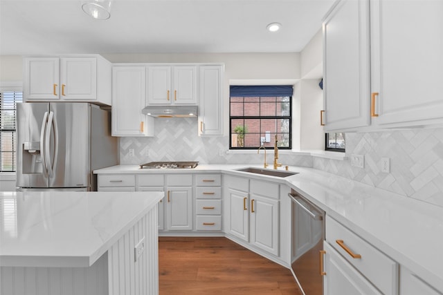 kitchen featuring white cabinets, stainless steel appliances, light hardwood / wood-style floors, sink, and decorative backsplash