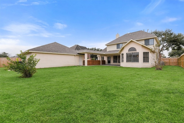 back of house featuring a patio and a lawn