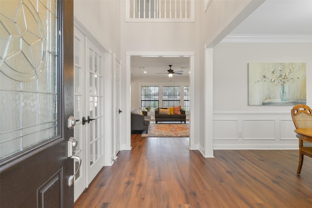 foyer entrance with ceiling fan, french doors, crown molding, and dark hardwood / wood-style flooring