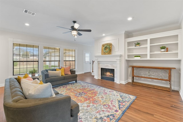 living room featuring hardwood / wood-style floors, ceiling fan, and ornamental molding