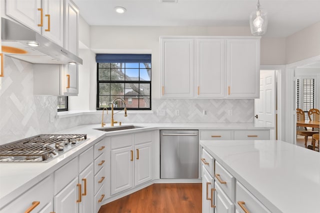 kitchen with sink, white cabinets, decorative light fixtures, and appliances with stainless steel finishes