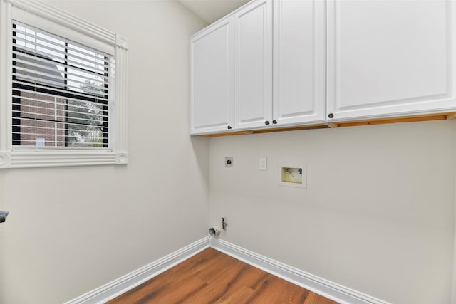 washroom featuring washer hookup, hardwood / wood-style flooring, electric dryer hookup, and cabinets