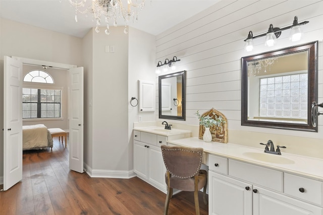 bathroom featuring vanity, a chandelier, wood walls, and hardwood / wood-style floors