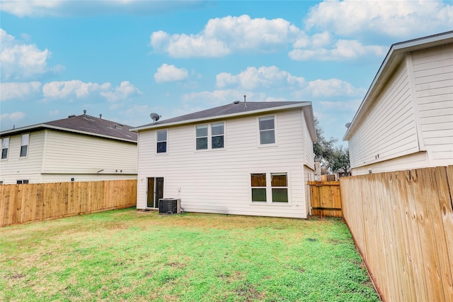 rear view of property with a yard and central AC