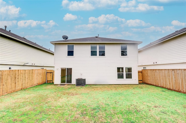 rear view of property featuring cooling unit and a yard