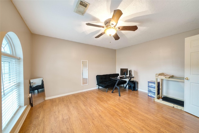 office area with ceiling fan, a textured ceiling, and light hardwood / wood-style flooring