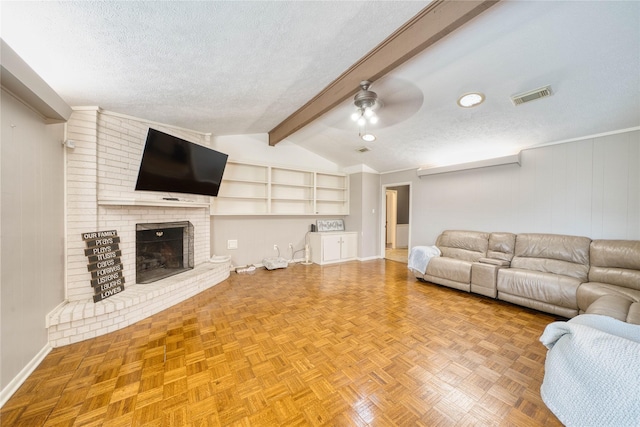 unfurnished living room featuring a fireplace, a textured ceiling, parquet flooring, vaulted ceiling with beams, and ceiling fan