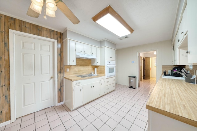 kitchen featuring black electric cooktop, white cabinetry, oven, and ceiling fan