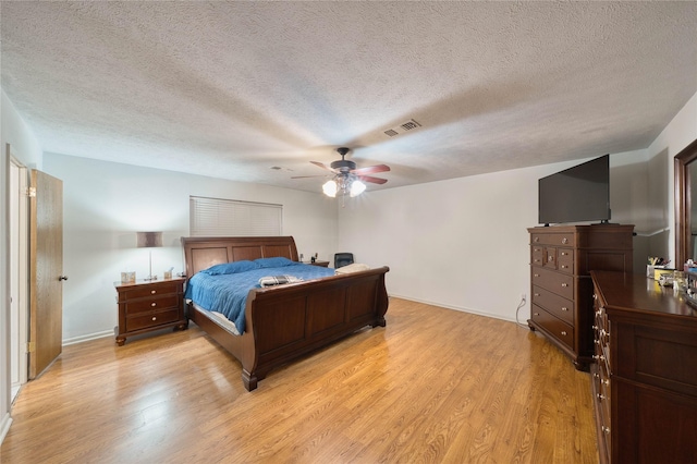 bedroom with light wood-type flooring, a textured ceiling, and ceiling fan