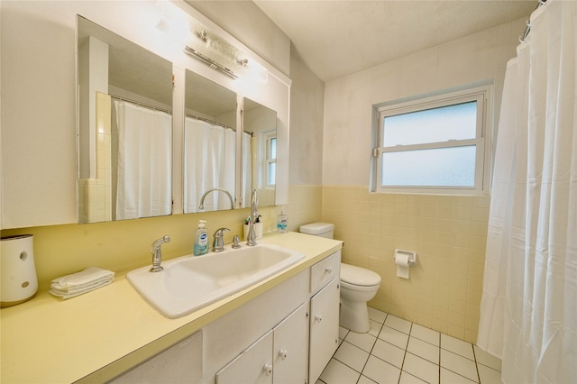 bathroom with tile patterned floors, tile walls, toilet, and vanity