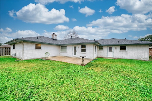 rear view of house with a lawn and a patio