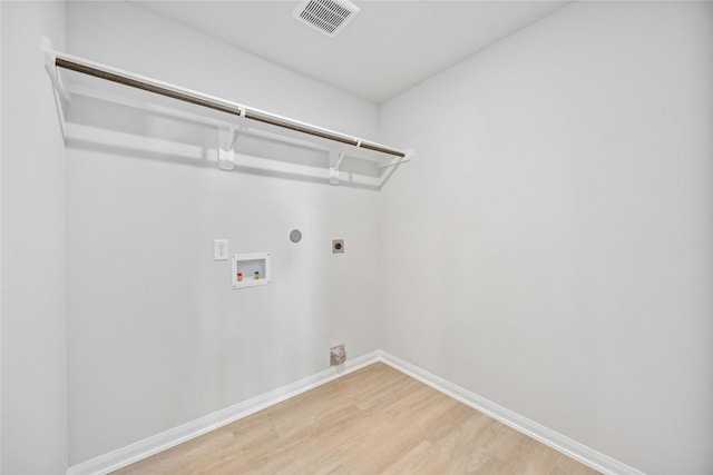 laundry room featuring hookup for a washing machine, gas dryer hookup, hardwood / wood-style flooring, and hookup for an electric dryer