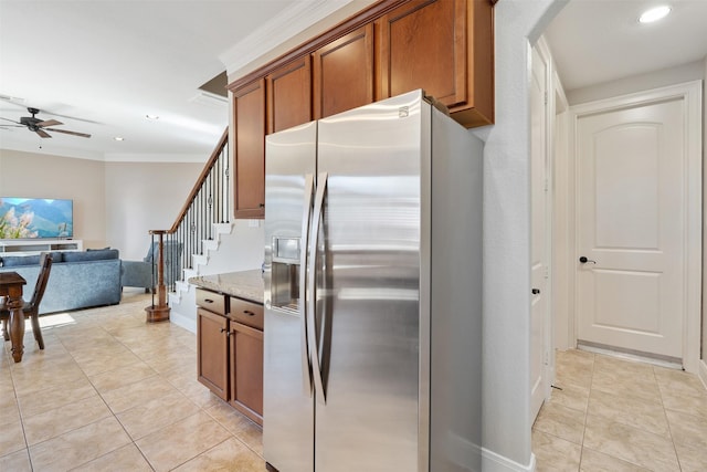 kitchen with ceiling fan, stainless steel fridge with ice dispenser, light stone counters, light tile patterned floors, and crown molding