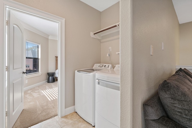 laundry room with crown molding, light colored carpet, and washer and clothes dryer