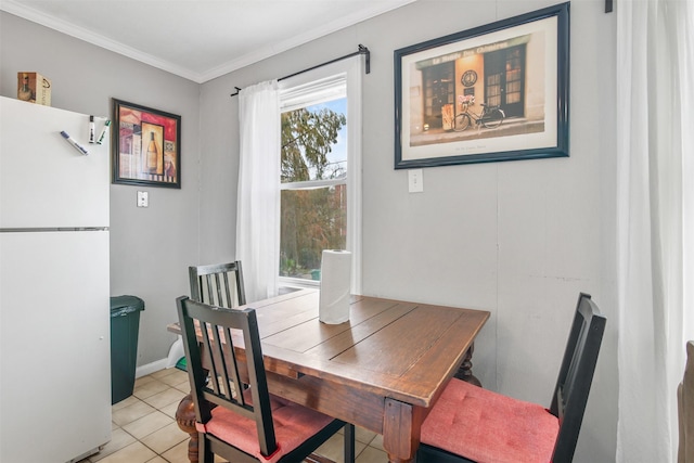 tiled dining space featuring crown molding