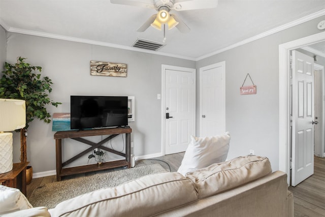 living room featuring ceiling fan, ornamental molding, and light wood-type flooring