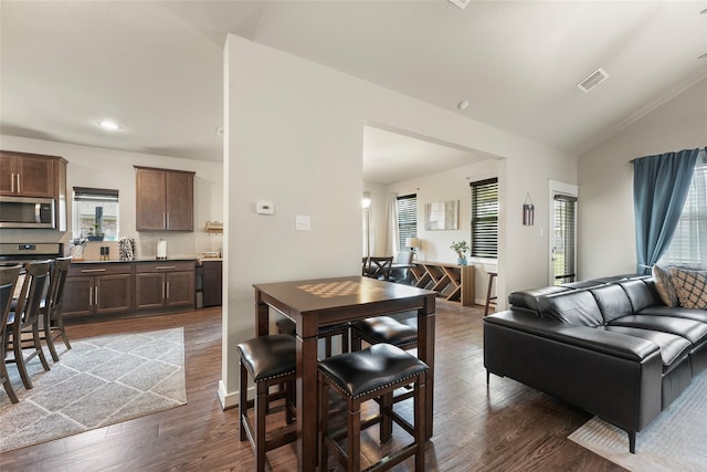 dining room with dark hardwood / wood-style floors and lofted ceiling