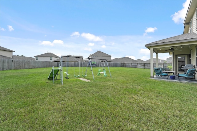 view of yard featuring ceiling fan, a playground, and a patio area