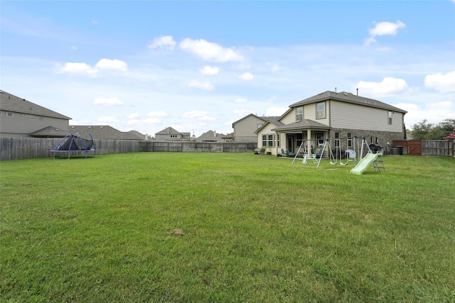 view of yard with a playground and a trampoline