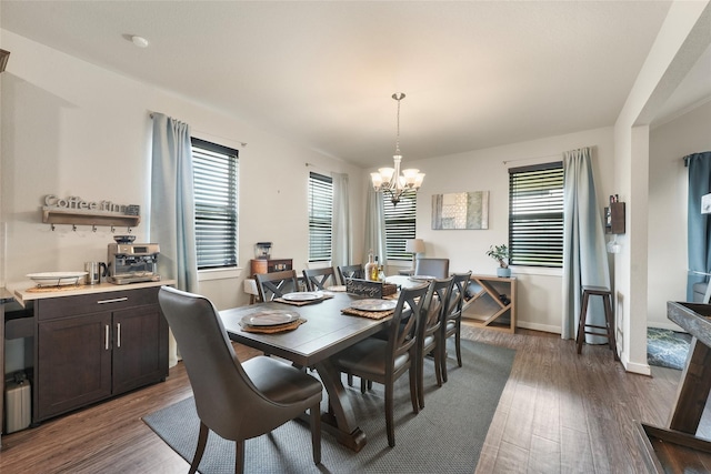 dining space featuring dark hardwood / wood-style floors and a chandelier