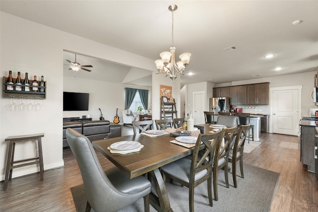 dining area featuring ceiling fan with notable chandelier and dark hardwood / wood-style floors