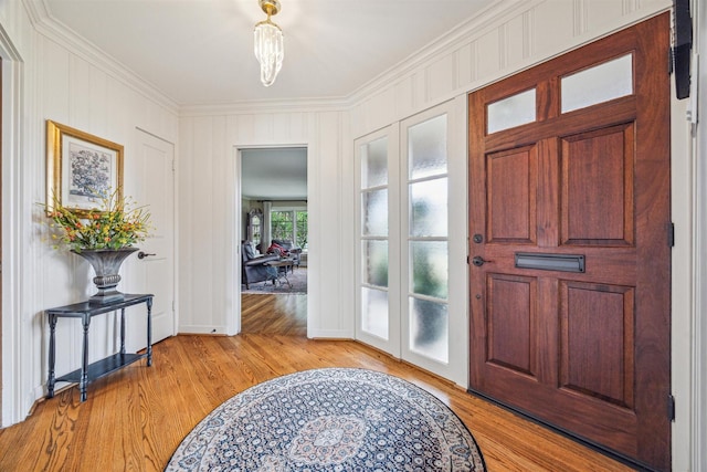 foyer with light wood-type flooring and ornamental molding