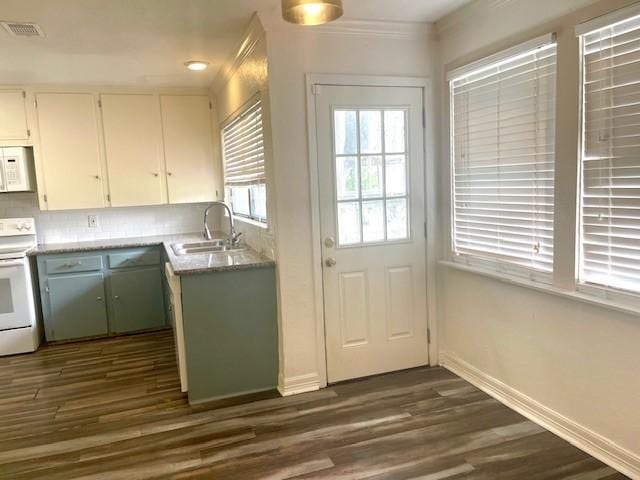 kitchen featuring sink, white cabinetry, tasteful backsplash, white appliances, and dark hardwood / wood-style floors