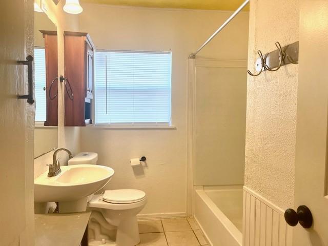 full bathroom with sink, toilet, tub / shower combination, and tile patterned floors