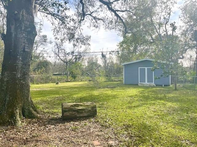 view of yard featuring an outbuilding, a storage unit, and fence