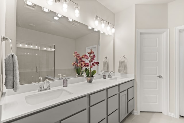 bathroom featuring vanity, a shower with shower door, and tile patterned floors