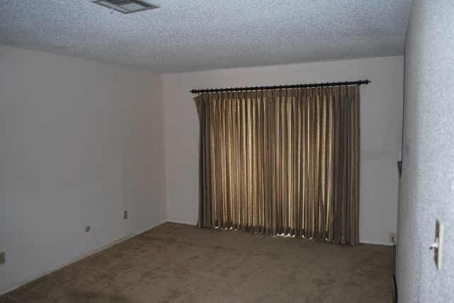 unfurnished room featuring a textured ceiling and carpet floors