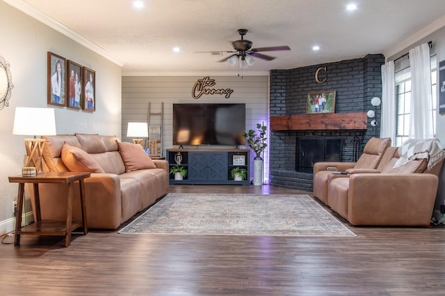 living room featuring hardwood / wood-style flooring, ornamental molding, a brick fireplace, and ceiling fan