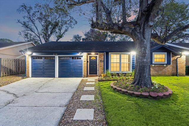 ranch-style house with a garage and a lawn