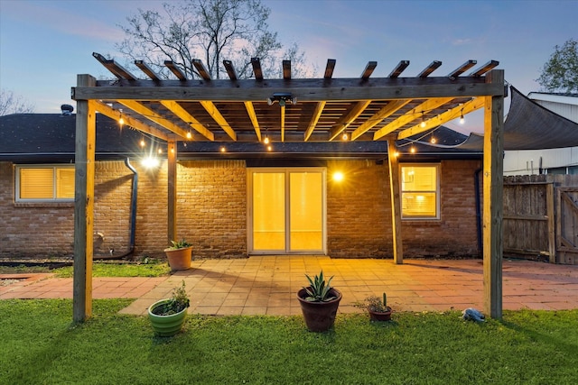 back house at dusk with a patio area and a pergola