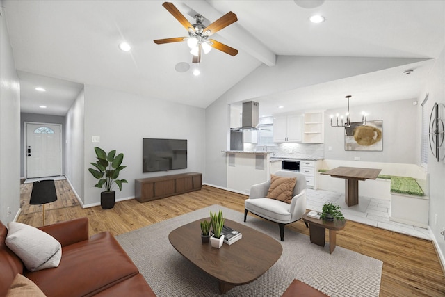 living room featuring ceiling fan with notable chandelier, vaulted ceiling with beams, and light wood-type flooring