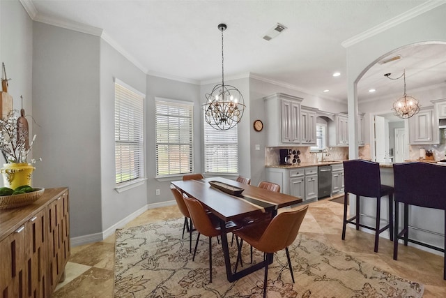 dining room featuring crown molding, sink, and a chandelier