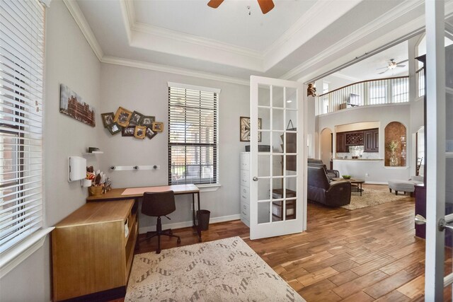 office with wood-type flooring, french doors, ceiling fan, a tray ceiling, and crown molding