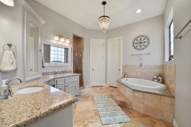 bathroom featuring vanity, separate shower and tub, and an inviting chandelier