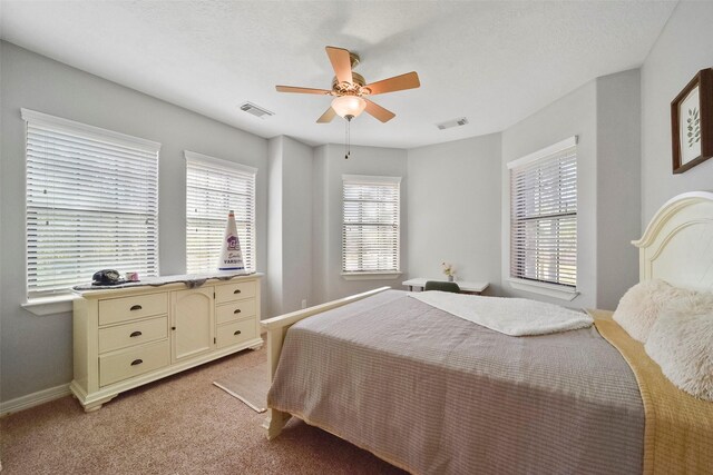 bedroom with ceiling fan, light carpet, and multiple windows