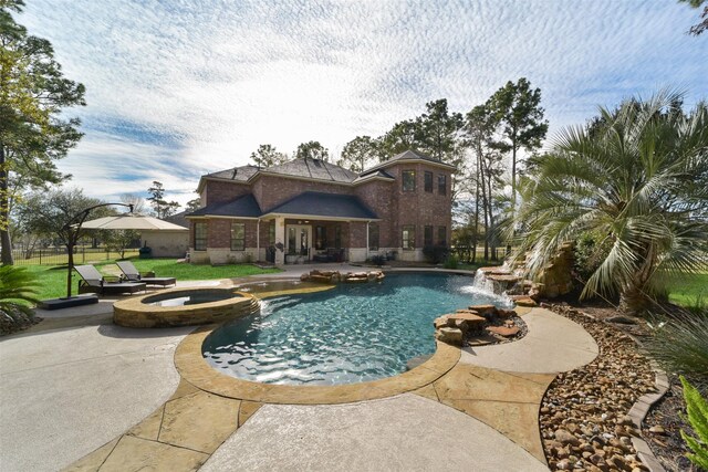 view of swimming pool featuring an in ground hot tub, pool water feature, and a patio