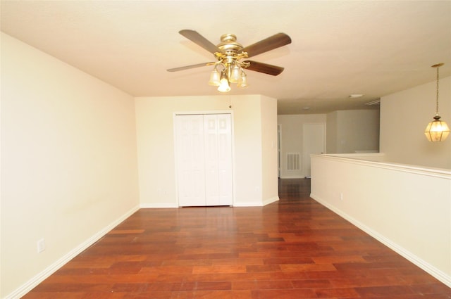 spare room with visible vents, ceiling fan, wood finished floors, and baseboards