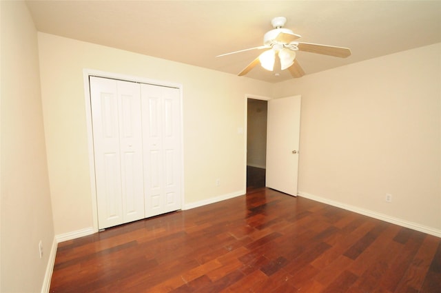 unfurnished bedroom featuring baseboards, wood finished floors, a ceiling fan, and a closet