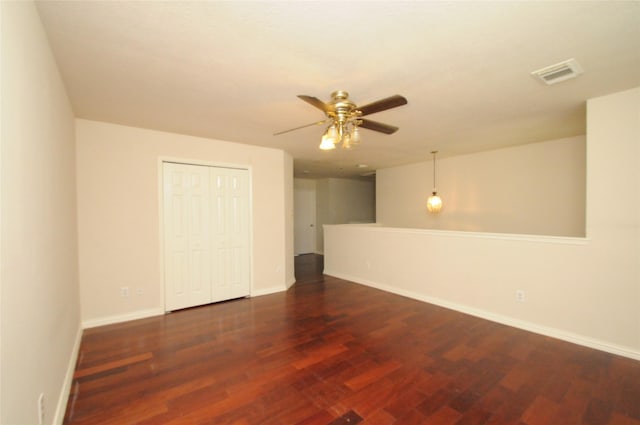 spare room featuring ceiling fan, baseboards, wood finished floors, and visible vents