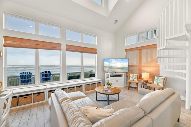 living area featuring high vaulted ceiling and light wood finished floors